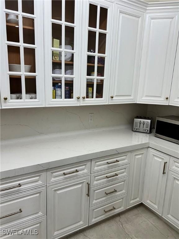 kitchen featuring white cabinetry and light stone countertops