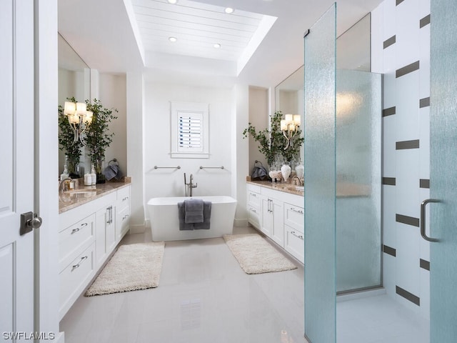 bathroom with a raised ceiling, separate shower and tub, vanity, and tile flooring