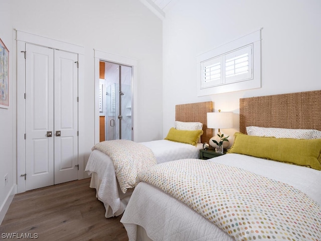 bedroom featuring ensuite bath and dark hardwood / wood-style flooring