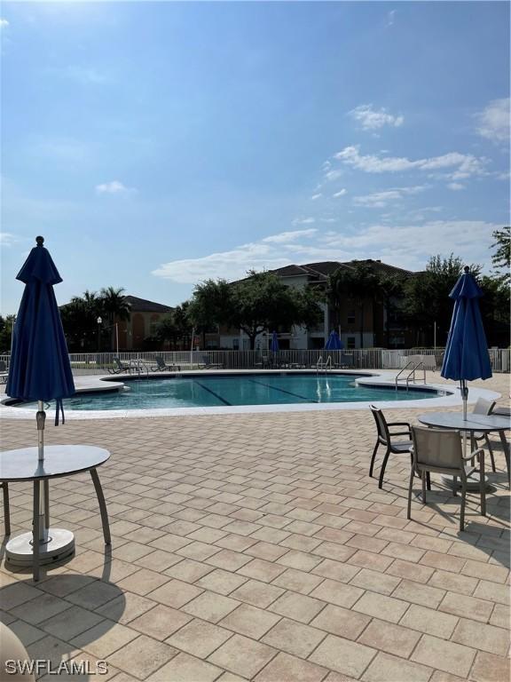 pool with a patio area and fence