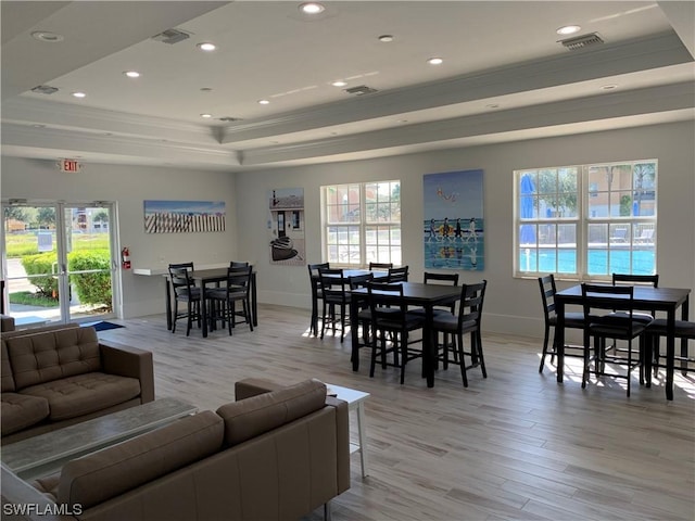 dining space with light wood-type flooring, a tray ceiling, visible vents, and recessed lighting