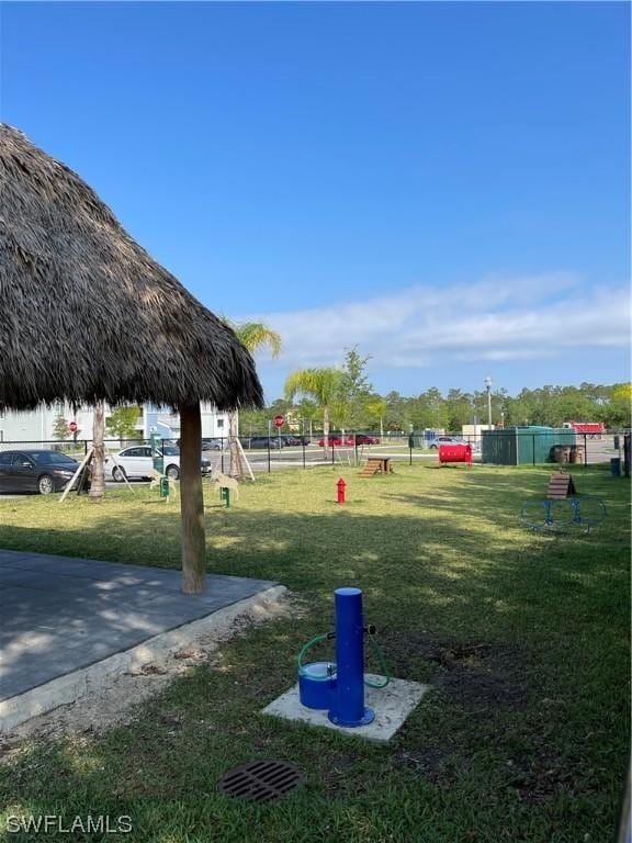 view of property's community with a lawn and fence