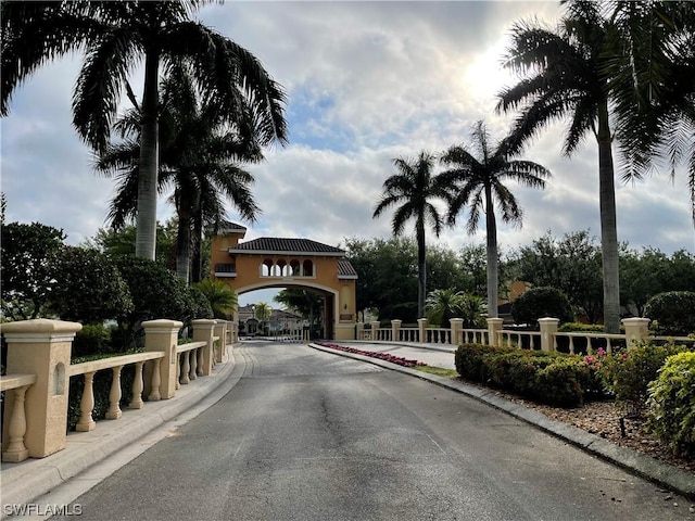 view of road with a gated entry and curbs