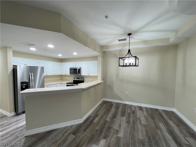 kitchen featuring appliances with stainless steel finishes, dark hardwood / wood-style flooring, white cabinetry, and pendant lighting