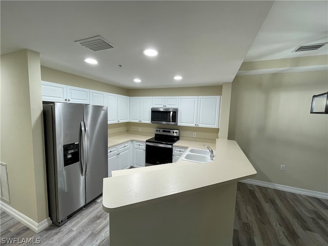 kitchen with a peninsula, visible vents, appliances with stainless steel finishes, and a sink