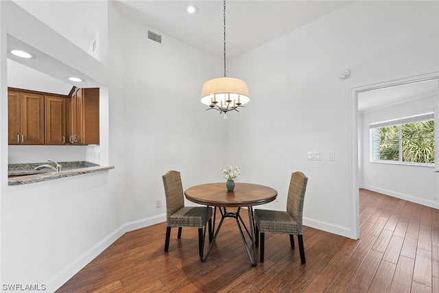 dining room featuring high vaulted ceiling, a notable chandelier, dark hardwood / wood-style floors, and sink