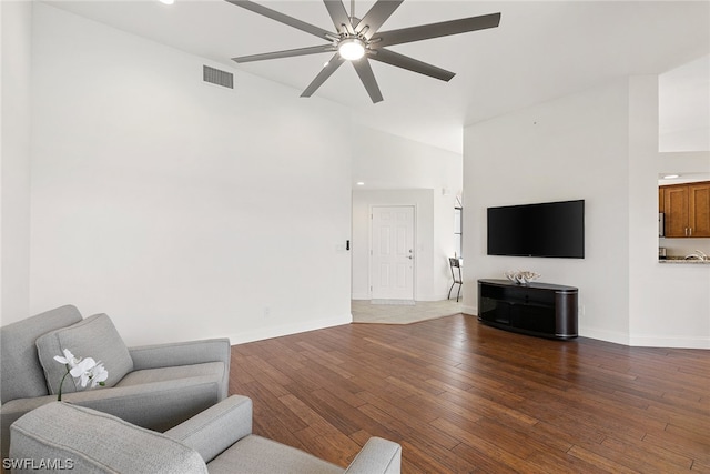 living room featuring dark wood-type flooring, high vaulted ceiling, and ceiling fan