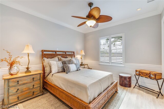 bedroom with light hardwood / wood-style flooring, ceiling fan, and ornamental molding