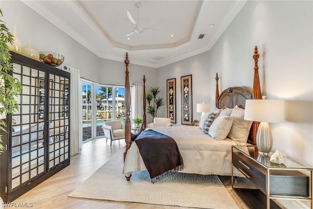 bedroom with access to exterior, french doors, a raised ceiling, crown molding, and light hardwood / wood-style flooring