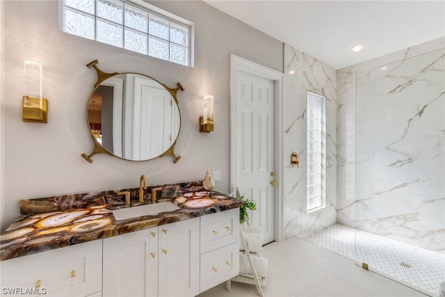 bathroom featuring tile patterned floors, vanity, and tiled shower