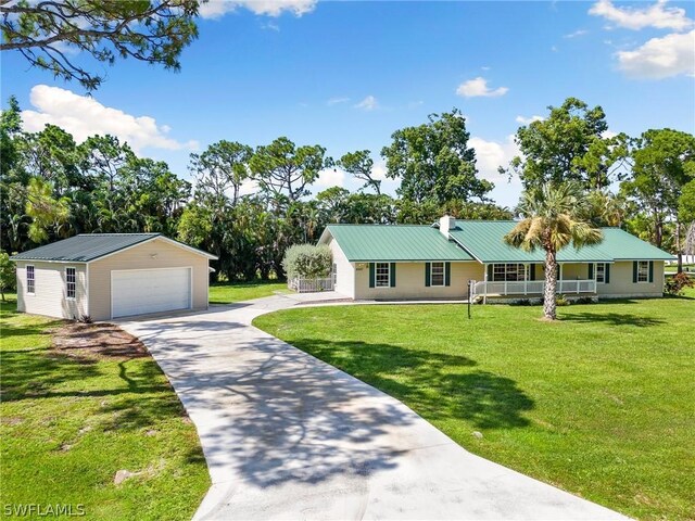 ranch-style house featuring a garage, a front lawn, and an outbuilding