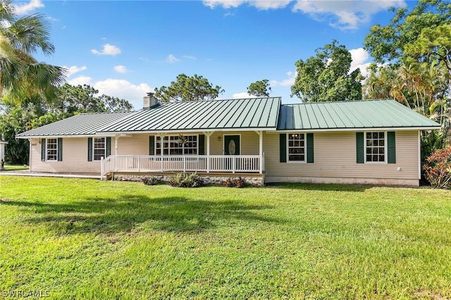 back of property featuring covered porch and a lawn