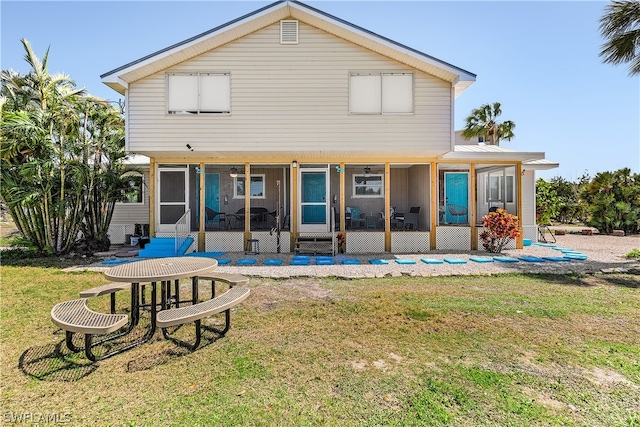 rear view of property featuring a lawn