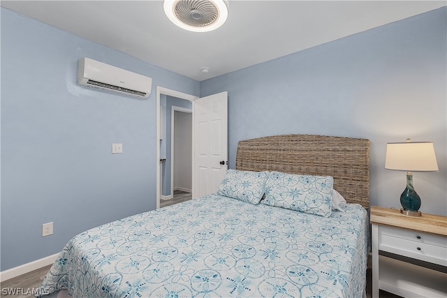 bedroom featuring a wall mounted air conditioner and wood-type flooring