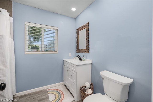 bathroom with oversized vanity, toilet, and wood-type flooring