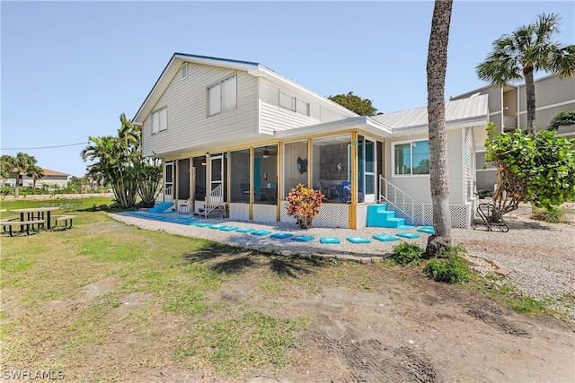 back of house with a yard, a sunroom, and a patio area