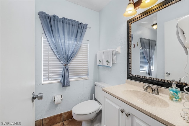 bathroom with toilet, tile floors, and vanity with extensive cabinet space