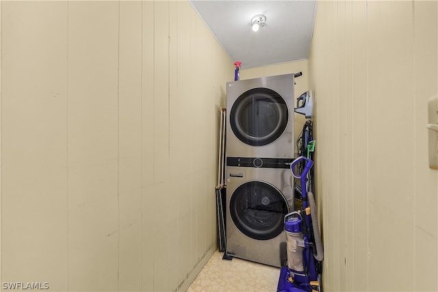 laundry room with light tile floors and stacked washer and dryer