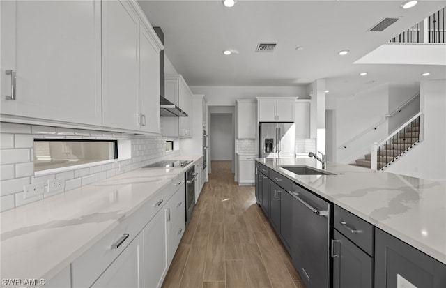 kitchen featuring sink, appliances with stainless steel finishes, tasteful backsplash, and light hardwood / wood-style floors