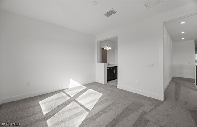 unfurnished room with carpet flooring and an inviting chandelier