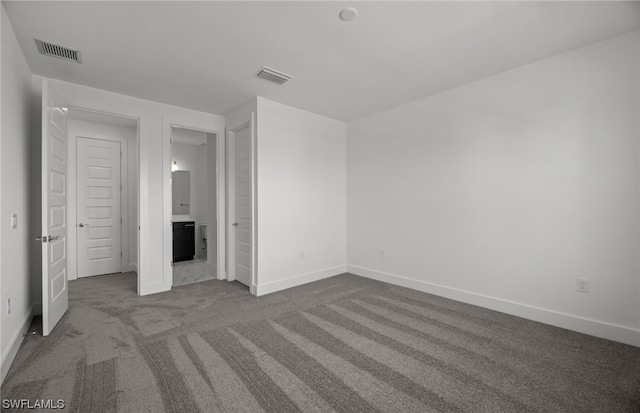 unfurnished bedroom with dark carpet