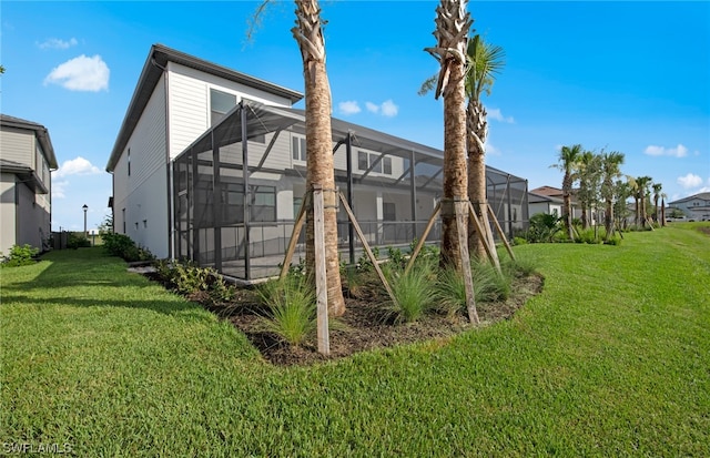 back of property with a yard and glass enclosure