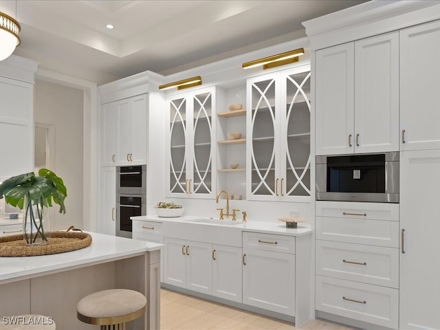 kitchen featuring a kitchen breakfast bar, white cabinetry, sink, and stainless steel appliances