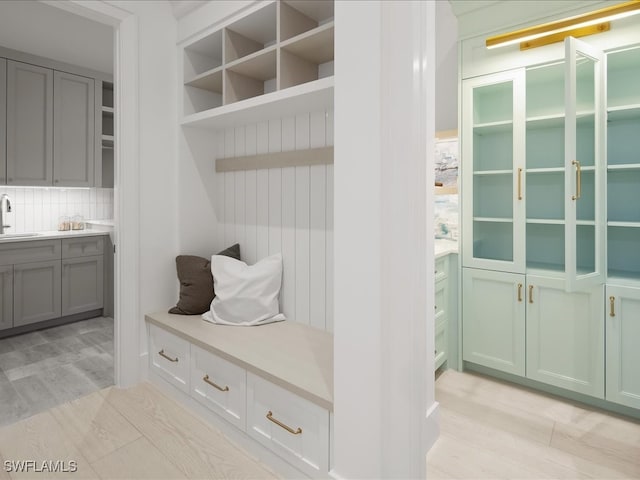 mudroom with light hardwood / wood-style flooring and sink