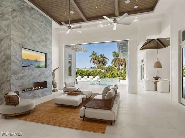 living area with beam ceiling, wooden ceiling, tile walls, and a premium fireplace