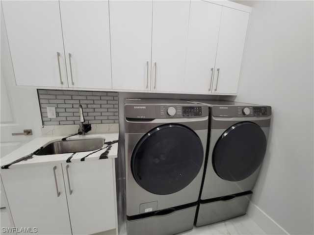 washroom featuring washer and dryer, cabinets, and sink