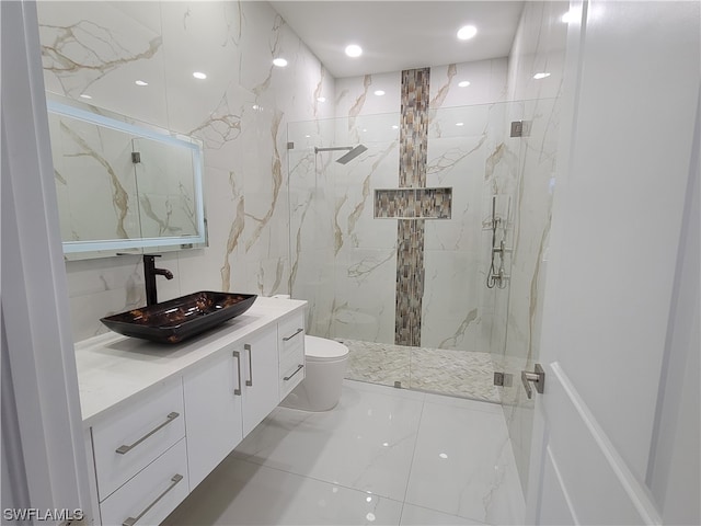 bathroom with tiled shower, vanity, and toilet