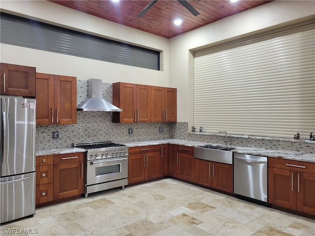 kitchen with wall chimney exhaust hood, wood ceiling, stainless steel appliances, ceiling fan, and light stone counters