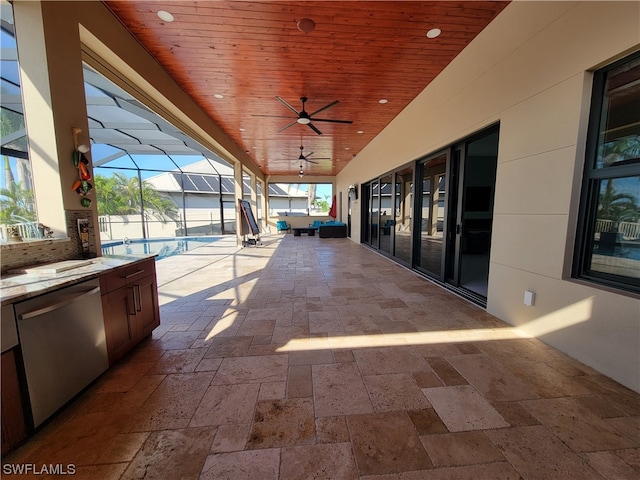 view of patio with glass enclosure, area for grilling, and ceiling fan