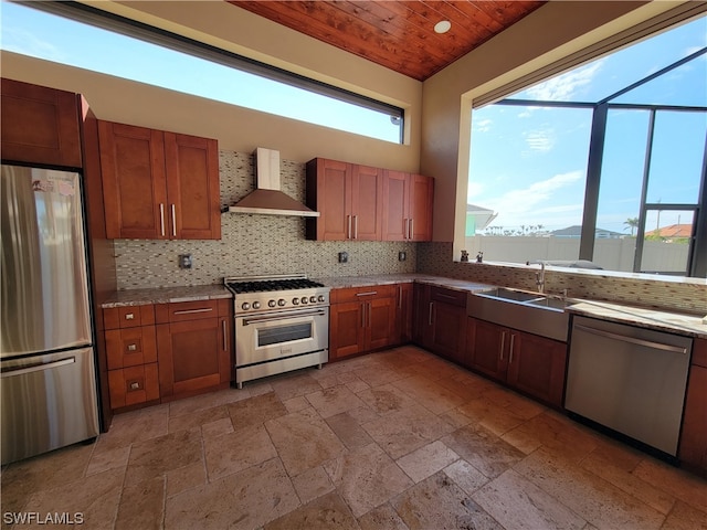 kitchen with backsplash, stainless steel appliances, sink, and wall chimney exhaust hood