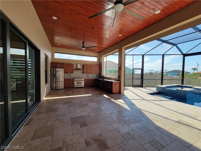 unfurnished sunroom featuring ceiling fan and wood ceiling