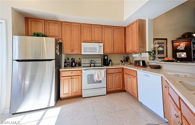 kitchen featuring white appliances and light tile floors