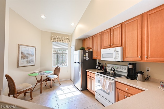 kitchen with light tile floors, vaulted ceiling, and white appliances