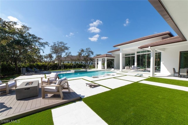 view of swimming pool with a patio, a fire pit, and a lawn
