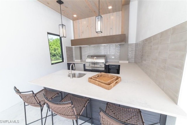 kitchen with sink, a breakfast bar area, wood ceiling, decorative light fixtures, and kitchen peninsula