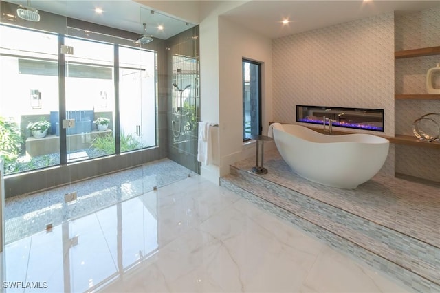 bathroom featuring a wealth of natural light and separate shower and tub
