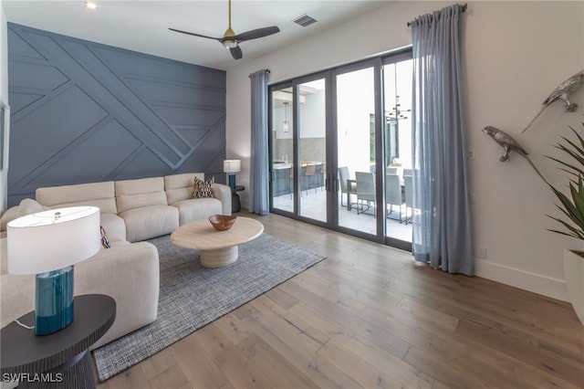 living room featuring french doors, ceiling fan, and light wood-type flooring