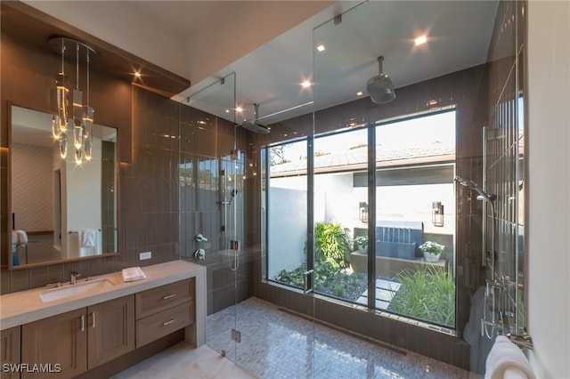 bathroom with vanity, tile walls, and a shower with shower door