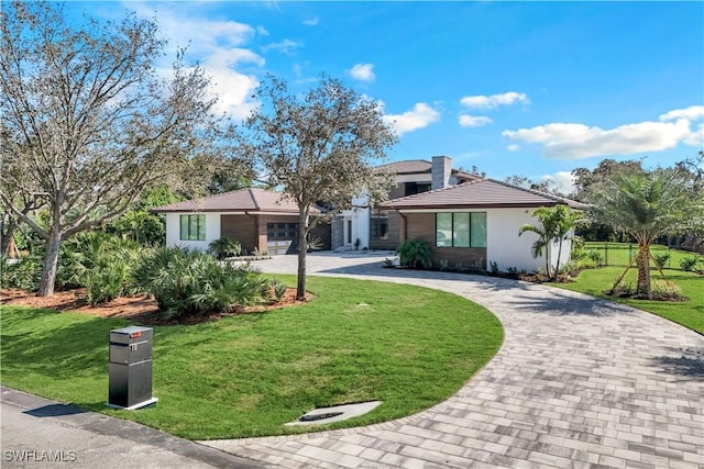 single story home featuring a garage and a front lawn