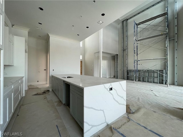 kitchen with white cabinetry, ornamental molding, gray cabinets, a kitchen island, and light stone countertops