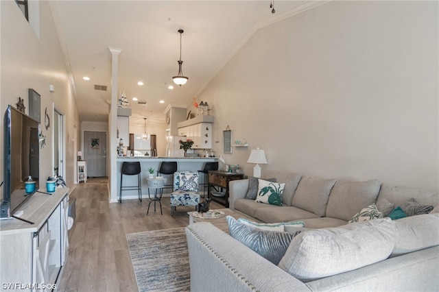 living room with high vaulted ceiling, light wood-type flooring, and crown molding