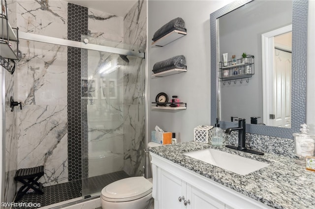 bathroom featuring large vanity, toilet, and a shower with door