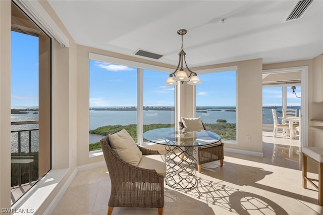 sunroom / solarium featuring a water view and a healthy amount of sunlight