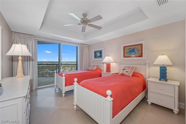 bedroom featuring access to exterior, ceiling fan, and a tray ceiling