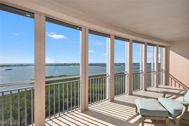 unfurnished sunroom with a healthy amount of sunlight and a water view