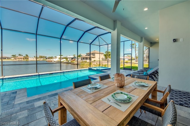 view of swimming pool with a water view, a patio area, and a lanai